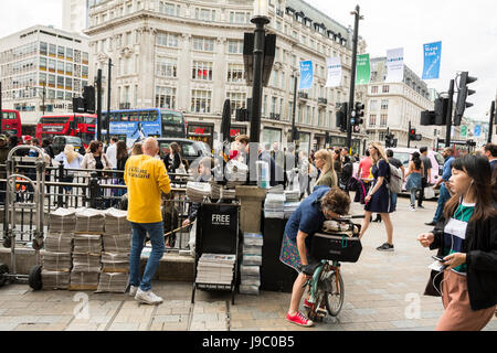 An Evening Standard newspaper vendor at Oxford Circus tube station, London, UK Stock Photo