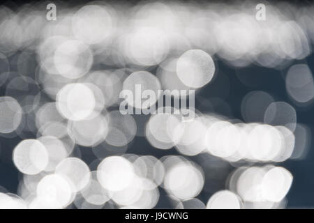 Water bokeh background. Defocused water surface with waves glittering in the sun Stock Photo