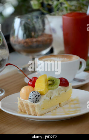 Green Tea with red bean roll cake and latte art on wood table. Stock Photo