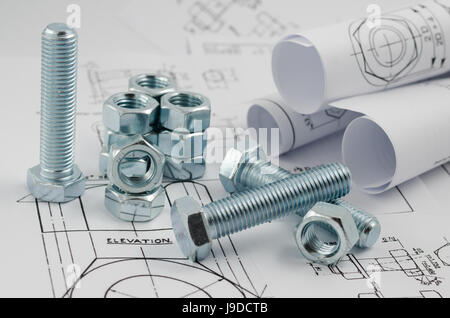 Mechanical Engineering Technology. Nuts and bolts on paper drawings Stock Photo