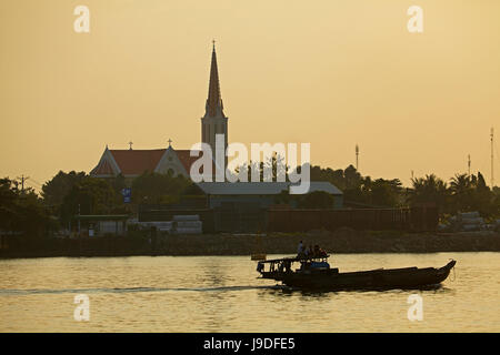 Boat on Co Chien River (branch of Mekong River), and silhouette of church, Vinh Long, Mekong Delta, Vietnam Stock Photo