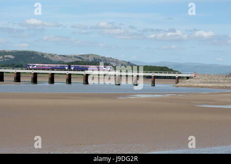 Class 156 super sprinter dmu operated by Northern at Arnside on the Furness line crossing the River Kent as it flows under Arnside viaduct. Stock Photo