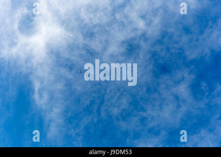 Light aircraft flying from right to left on blue sky day. Stock Photo