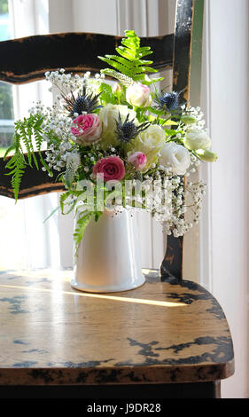 bridal bouquet in white vase on old chair Stock Photo