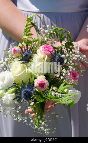 bridesmaid holding bouquet of flowers Stock Photo