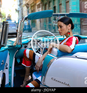HAVANA, CUBA - 11 DECEMBER 2016:  Cuban woman is getting the classical American car off in the centre of old Havana Stock Photo