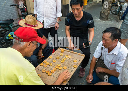 Chinese senior citizens playing board game in the street, Shanghai, China Stock Photo