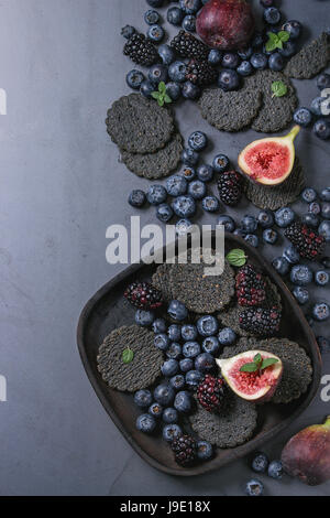 Variety of berries and figs with black crackers Stock Photo