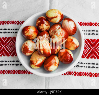Easter eggs natural decorated with spring leaves, red painted with onion shells Stock Photo