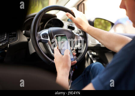 Young Man Using Satellite Navigation on Phone Whilst Driving Stock Photo