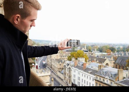 Tourist Taking Photo Of Oxford Skyline On Mobile Phone Stock Photo