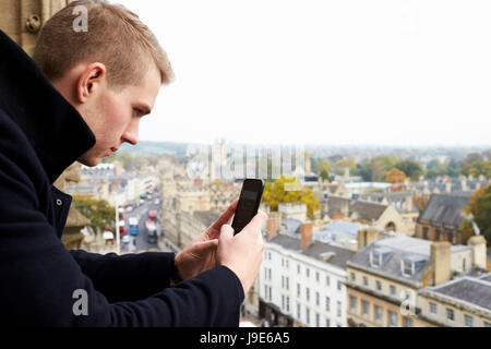 Tourist Taking Photo Of Oxford Skyline On Mobile Phone Stock Photo