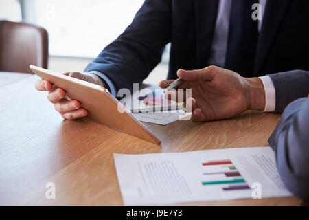 Close Up Of Businessmen Using Digital Tablet In Meeting Stock Photo