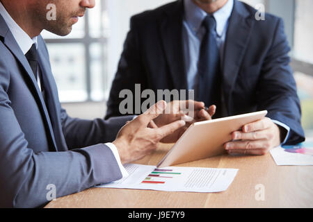 Close Up Of Businessmen Using Digital Tablet In Meeting Stock Photo