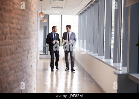 Two Businessmen Having Informal Meeting In Office Corridor Stock Photo