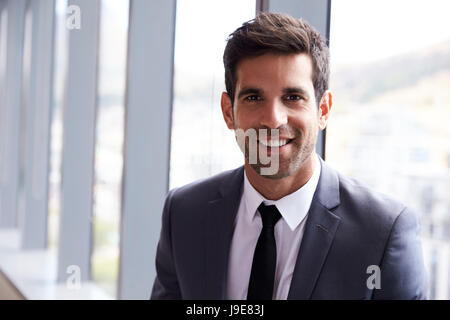 Head And Shoulders Portrait Of Young Businessman In Office Stock Photo