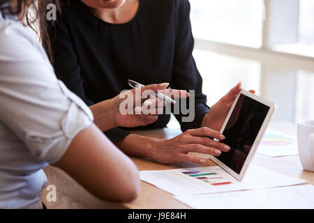 Close Up Of Businesswomen Using Digital Tablet In Meeting Stock Photo