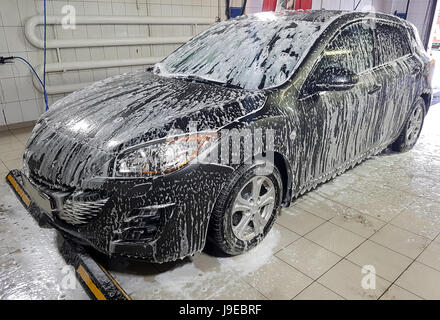 Car wash with foam in car wash station. Carwash. Washing machine at the