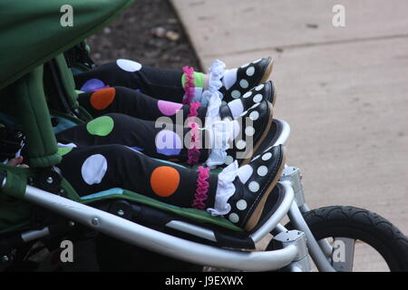 Cute little feet of twins in stroller Stock Photo