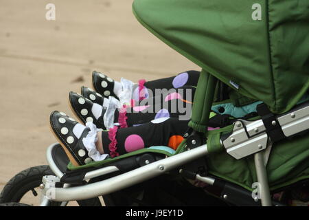 Cute little feet of twins in stroller Stock Photo