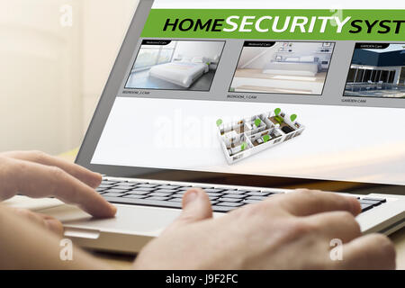 security concept: man using a laptop with cctv on the screen. Screen graphics are made up. Stock Photo
