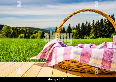 Picnic basket on wooden table Stock Photo