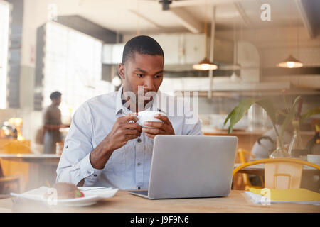 Businessman Working In Coffee Shop Shot Through Glass Stock Photo