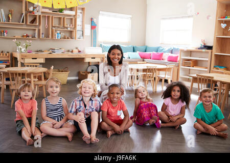 Portrait Of Teacher With Pupils In Montessori School Classroom Stock Photo