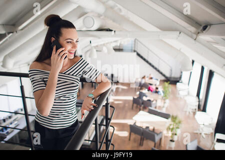 Feminine gossip while relaxing in her own cafe. Stock Photo
