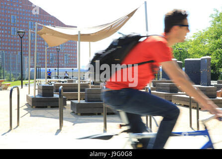 Cyclist in trendy East Village, former home of the Olympic athletes, in Stratford E20, east London, UK Stock Photo