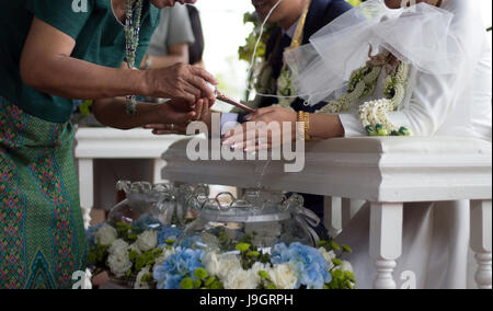 close up hand of parent praying with water to blasing to groom and bridge hand in thai wedding ceremony Stock Photo