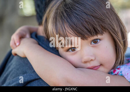 Four year old girl being carried by her Dad Stock Photo