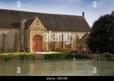 UK England, Dorset, Abbotsbury, Church Street, Medieval former Benedictine Abbey Tithe Barn across fish pond Stock Photo