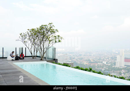 working at the top of buliding with view of Jakarta landscape Stock Photo