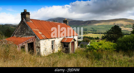 A scruffy, tin-roofed traditional cottage at Garve in the Highlands of Scotland. Stock Photo