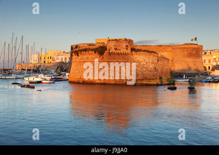 Old Town with fort, city wall and harbour with sunrise, Gallipoli, province of Lecce, Salento peninsula, Apulia, Italy Stock Photo