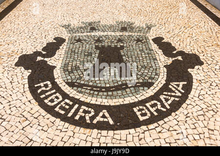 A calçada (Portugese style) pavement in Ribeira Brava, Madeira, showing the village coat of arms Stock Photo