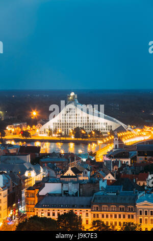 Riga, Latvia. Aerial View Of Cityscape In Summer Evening Or Night Lights Illumination. Top View Of Latvian National Library At Blue Hour Stock Photo