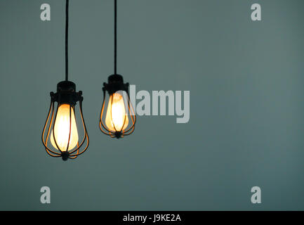 Yellow illuminated hanging light bulbs on plain light navy background with text space