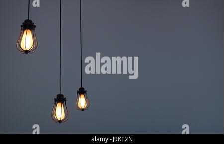 Hanging light bulbs on plain background with text space Stock Photo