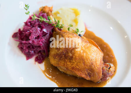 Duck confit with purple cabbage and mashed potato on white plate Stock Photo