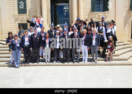 Tour group photo of carnival organisers on steps of Auberge de Castille palace in city centre of Valletta, Malta Stock Photo