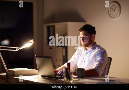 businessman typing on laptop at night office Stock Photo