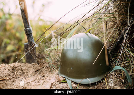 Metal Helmet And Sapper Shovel Of Infantry Soldier Of Soviet Russian Red Army During World War II, Lying On Sand In Trench.  Soldiers Military Ammunit Stock Photo