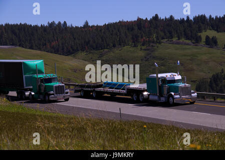 Two Classic Semi-Trucks Travel Together along a Rural Oregon, USA Highway. Stock Photo