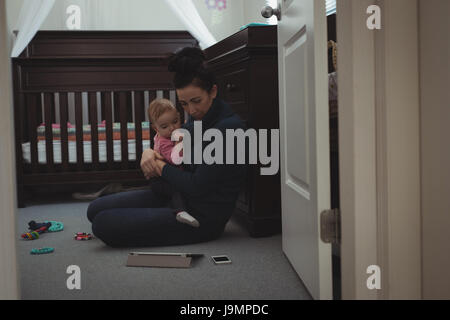 Mother and daughter using digital tablet in bedroom at home Stock Photo