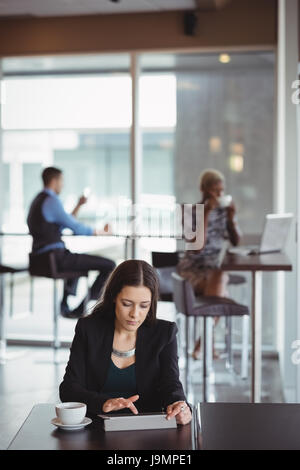Businesswoman using digital tablet in office cafeteria Stock Photo
