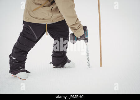Man working using drill machine in ski resort during winter Stock Photo