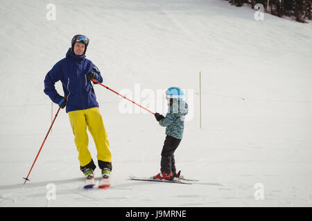 Father and daughter having fun while skiing during winter Stock Photo