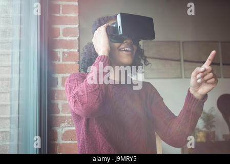 Woman using virtual reality headset at home Stock Photo